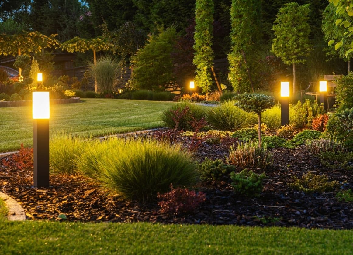 Jardin paysager équipé de bornes lumineuses assurant l’éclairage des espaces extérieurs à la tombée de la nuit.
